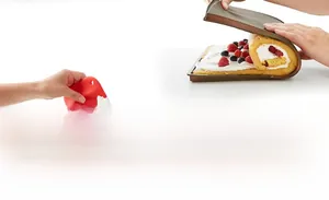 Close-up of flexible silicone baking mat and red spatula used for rolling a Swiss roll cake