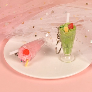 Close-up of pink strawberry and green matcha ice cream sundae charm keychain accessories