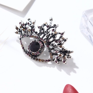 Elegant silver evil eye brooch featuring colorful rhinestones and branch design motifs
