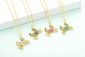 Detail of four colorful crab pendants with micro-set zircon on gold necklaces