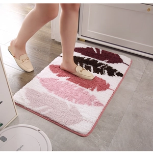 Detailed view of plush leaf pattern mat with feet for scale in bathroom setting