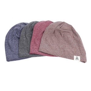 Vue à plat de quatre bonnets en tricot colorés avec étiquettes blanches et texture douce