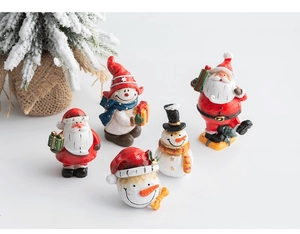 Close-up of resin Santa Claus and snowman miniatures for Christmas tabletop display