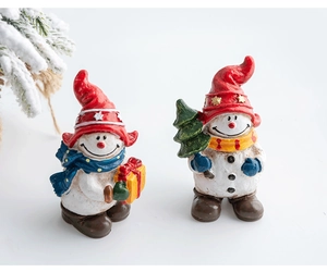 Detailed view of two festive Christmas resin snowman figurines for desktop holiday decoration