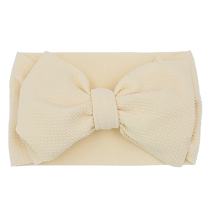 Detailed view of beige waffle textured fabric on large bow baby headband hair accessory