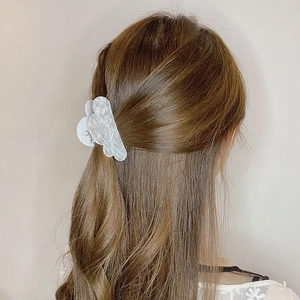 Close-up of a white cloud-shaped acrylic hair claw clip worn by a model on back view