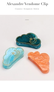 Detail of cloud-shaped acetate hair clips with celestial star and moon patterns