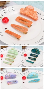 Detail of marble pattern acrylic cloud hair clips and barrettes on decorative white plate