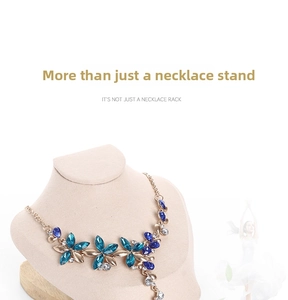 Blue gemstone floral necklace displayed on a beige velvet bust with a wooden base