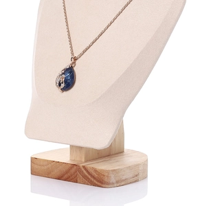 Close-up of a blue gemstone necklace with rose gold chain on a beige fabric neck display
