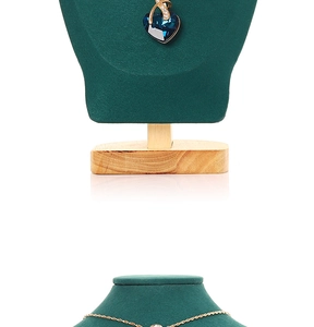 Detailed view of dark blue heart crystal necklace on green velvet bust display stand