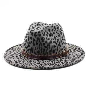 Close-up of leopard print fedora hat featuring wide brim and leather strap with buckle