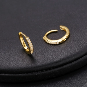 Detailed macro view of gold-plated earring hoops with micro-set white zircon stones