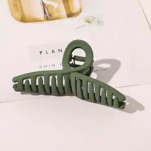 Macro shot of large matte green hair claw clip with strong metal spring and teeth