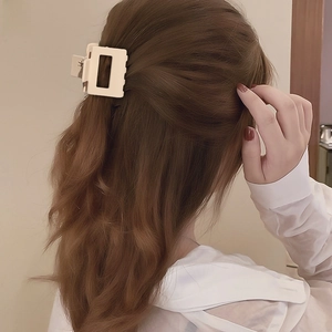 Matte cream large square hair claw clip on model with wavy hair from a back view