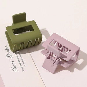 Detail of matte olive green and dusty pink hair claws with rectangle hollow design