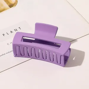 Detail view of large matte purple rectangle hair claw clip on a minimalist background