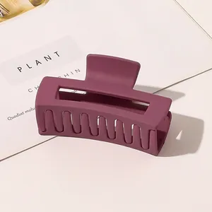 Close-up of matte dark purple rectangle hair claw clip with frosted texture detail