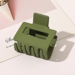 Macro detail of large olive green matte hair claw clip with a hollow rectangular design
