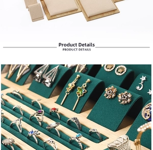 Macro detail of assorted vintage rings and earrings on a premium green velvet display tray