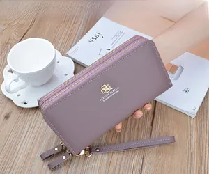 Detail of purple litchi texture long wallet with golden clover and double zipper design