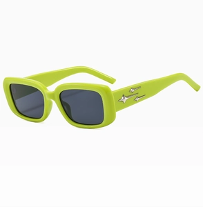 Dettaglio di occhiali da sole quadrati verde neon con decorazioni a stella d'argento