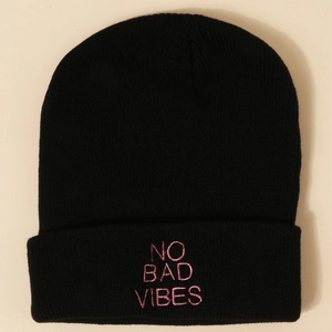 Détail de la broderie rose NO BAD VIBES sur un bonnet en tricot noir pour l'hiver