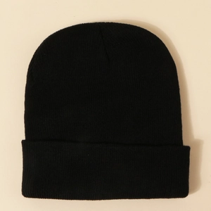 Vue détaillée de dessus d'un bonnet en maille noire avec texture côtelée et bord replié