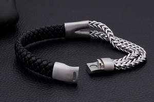 Macro detail of men's braided leather and silver stainless steel chain bracelet with magnetic clasp