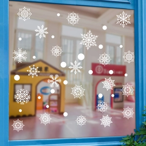 Detail of white snowflake and dot static window decals on glass with a home interior background