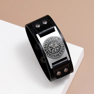 Detail of a Viking Vegvisir compass engraved on a silver metal plate on a black leather cuff