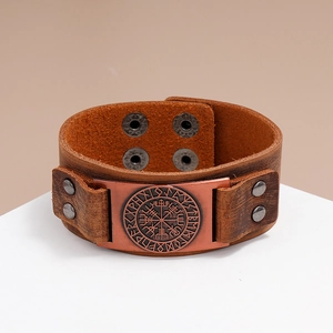 Close-up of brown leather bracelet with bronze Viking Vegvisir compass and rune plate