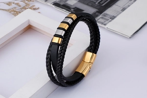 Détail du bracelet multicouche en cuir tressé avec fermoir magnétique doré et curseurs