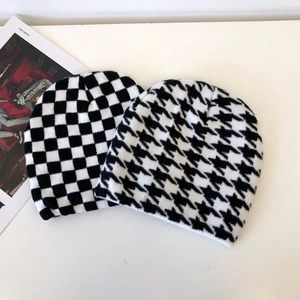 Detailed view of thick knitted beanies in classic checkerboard and houndstooth patterns