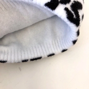 Detailed macro view showing the soft white lining and ribbed knit edge of the beanie