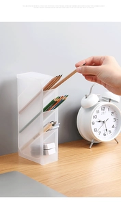 Macro view of transparent frosted slanted desk organizer showing four storage compartments