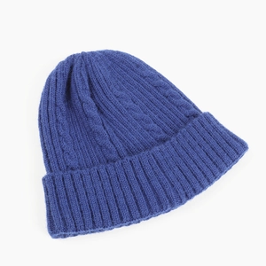 Close-up of royal blue cable knit beanie showing thick texture and ribbed hem detail