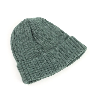 Detailed cable knit pattern on dark green winter beanie with thick ribbed cuff texture