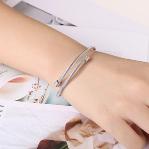 Minimalist silver steel cable open cuff bracelet for women shown on wrist