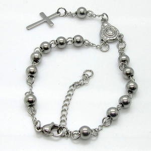 Dettaglio del bracciale rosario in perline di acciaio inossidabile con croce e medaglia