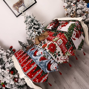 Festive Christmas table runner with tassels featuring Santa, snowman and bird patterns
