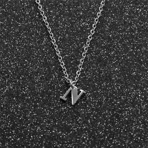 Minimalist silver stainless steel necklace featuring a 3D letter N pendant on a black backdrop