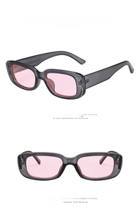 Detail view of small rectangular sunglasses with transparent grey frame and pink lenses
