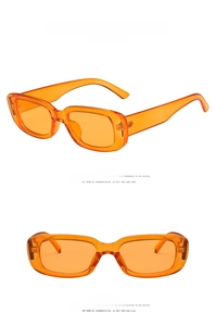 Detail view of transparent orange rectangle sunglasses with trendy narrow frames