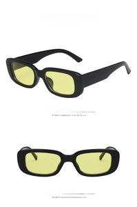 Detail view of retro rectangle sunglasses with black frame and vibrant yellow lenses
