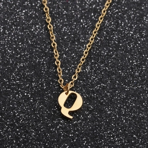 Detailed view of a golden letter Q pendant on an O-chain necklace against a black background