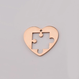 Detailed view of a rose gold heart puzzle piece pendant with a polished mirror finish