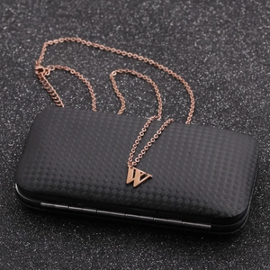 Minimalist rose gold stainless steel letter W pendant necklace on a black textured box