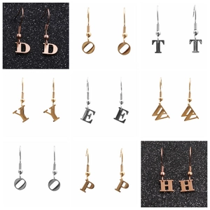 Detailed grid view of minimalist metal initial pendant earrings in gold and silver