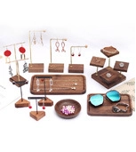 Detail of walnut wood jewelry display stands with gold metal supports and tiered trays